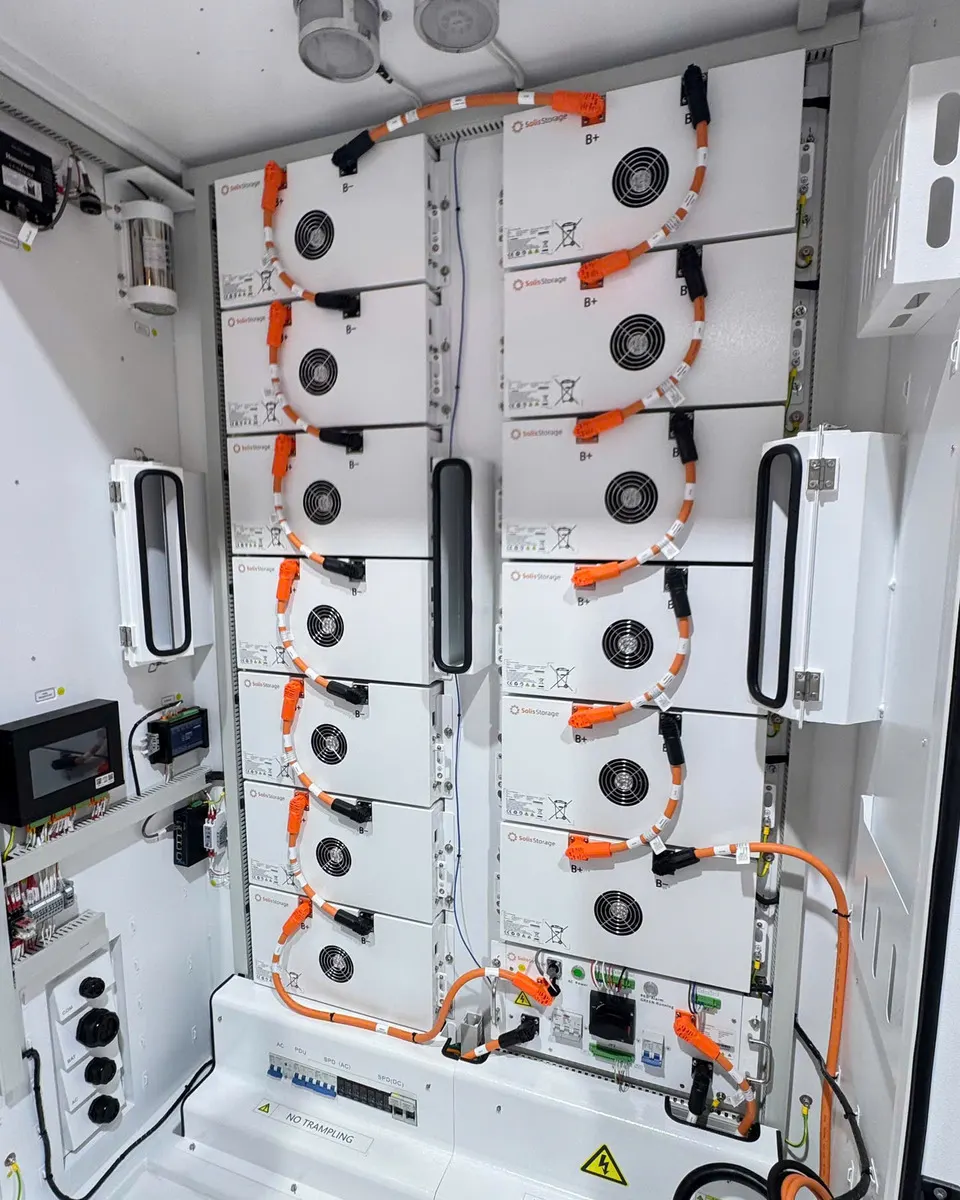 Bên trong tủ pin lưu trữ Solis Storage mở cửa, các module pin có quạt nối tiếp bằng cáp nguồn màu cam